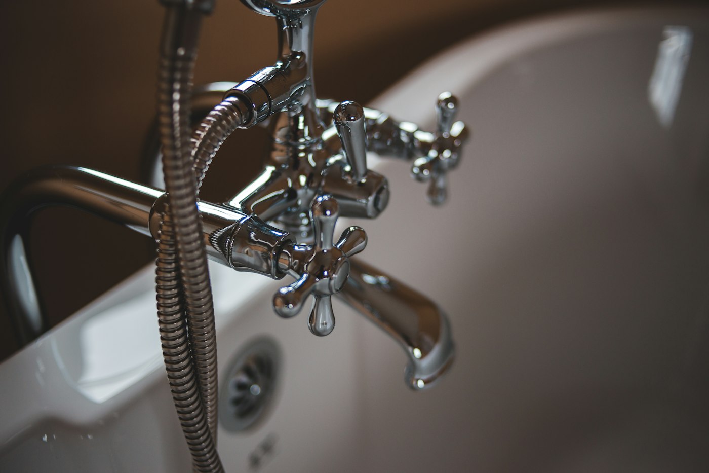White bathtub and plumbing fixtures in a bright bathroom