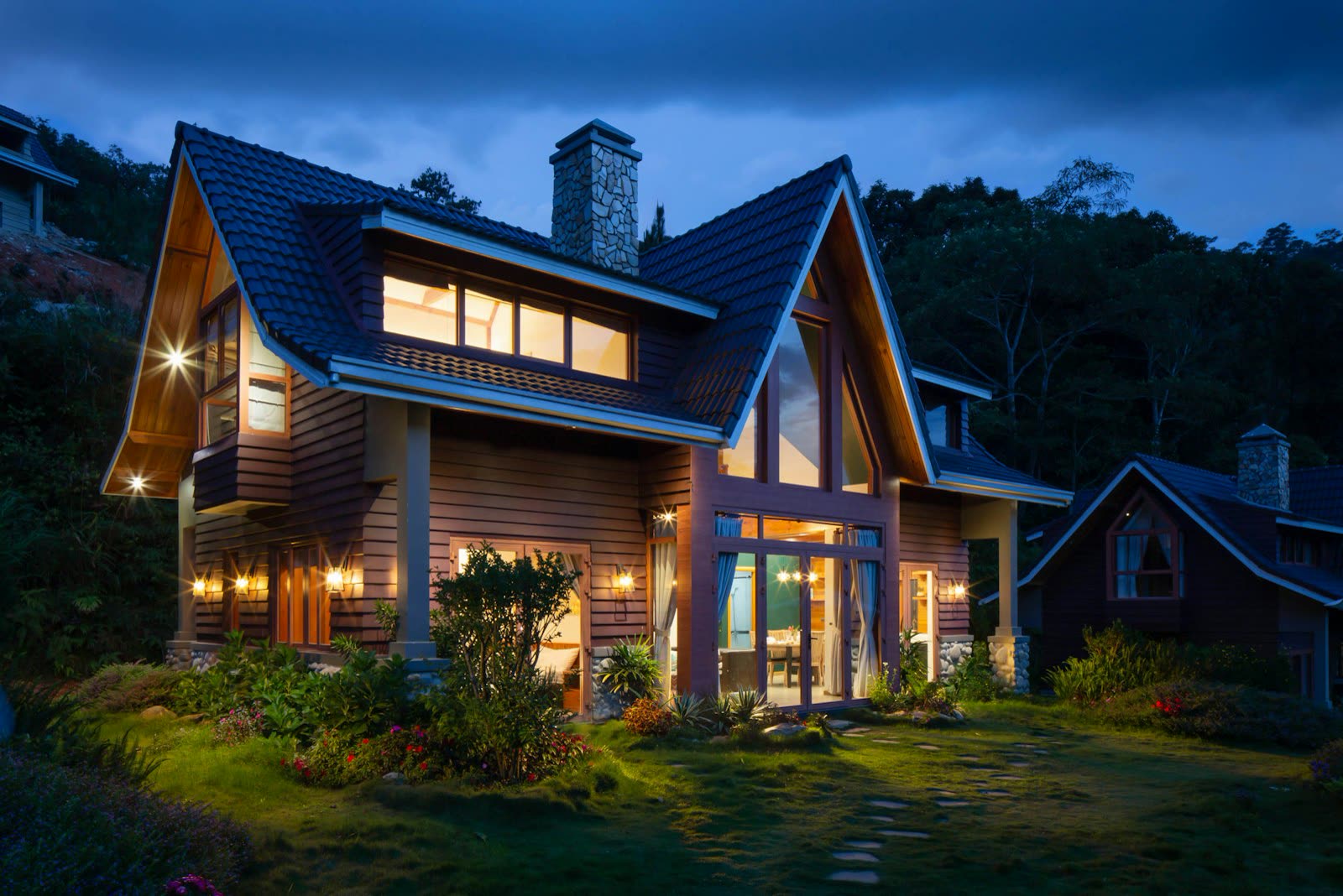 Finished two-story house with a dark shingled roof and a green lawn